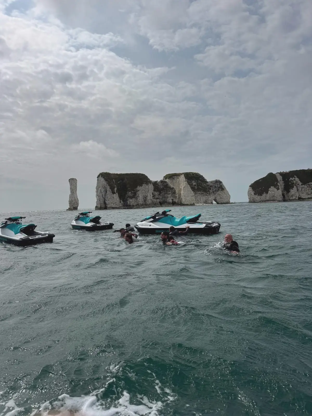 Team in the water next to jet skis at Old Harry Rocks