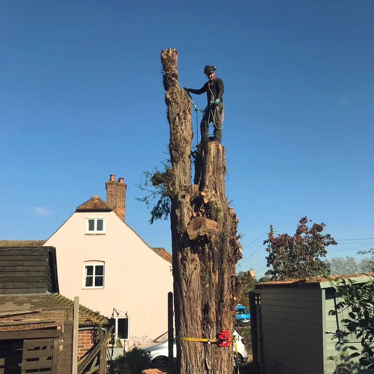 Climber dismantling a trunk next to a house
