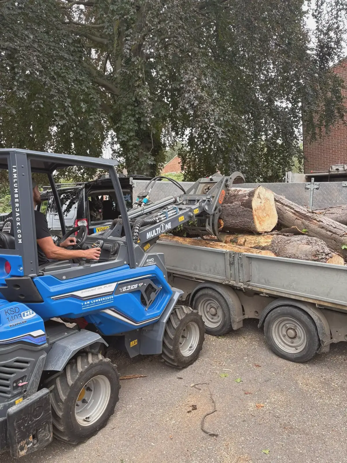 Multi-One loader carrying logs to a trailer